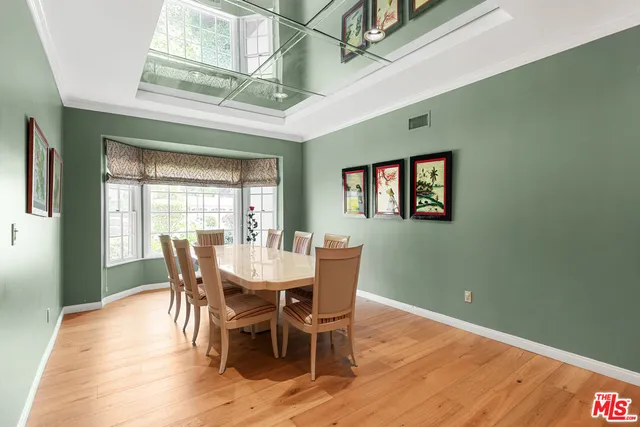 a dining room with furniture a chandelier and wooden floor