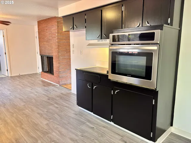 a kitchen with stainless steel appliances kitchen island granite countertop a stove and a microwave