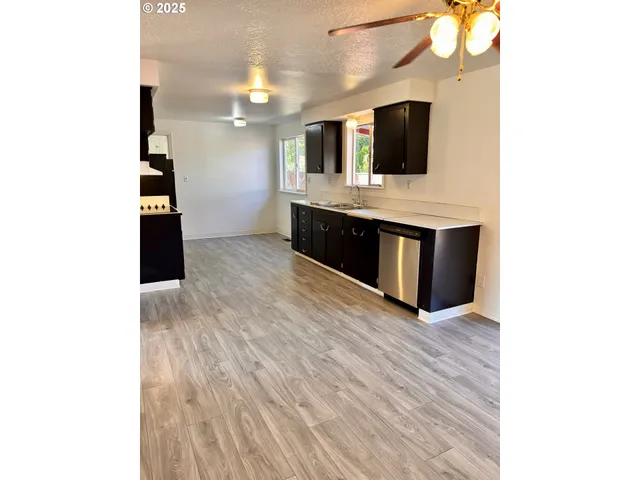 a large white kitchen with granite countertop a sink and a microwave