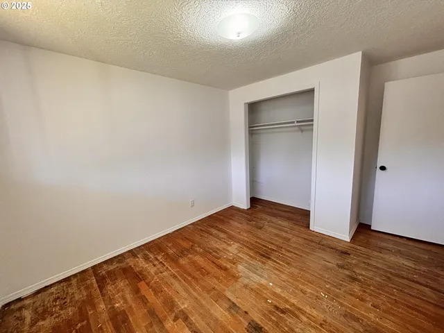 an empty room with wooden floor and closet