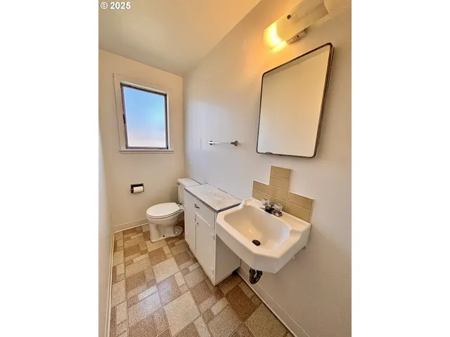 a bathroom with a toilet sink and mirror