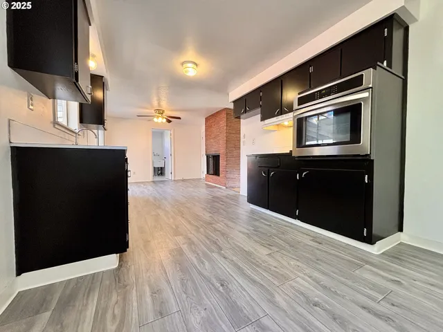 a kitchen with stainless steel appliances wooden cabinets and a wooden floor