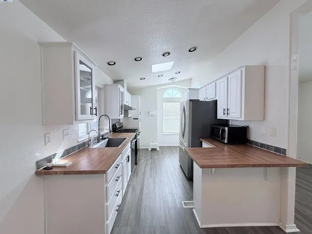 a kitchen with stainless steel appliances a sink stove and refrigerator