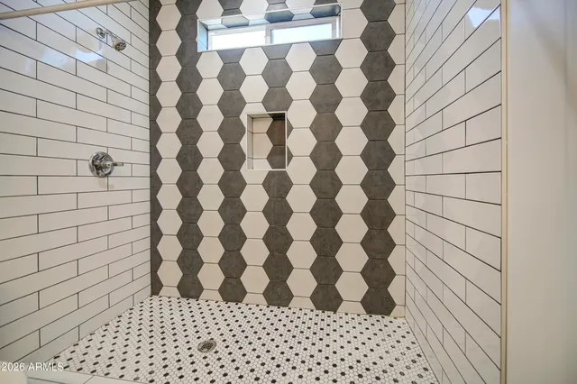 a bedroom with a bed and a flat tv screen on dresser