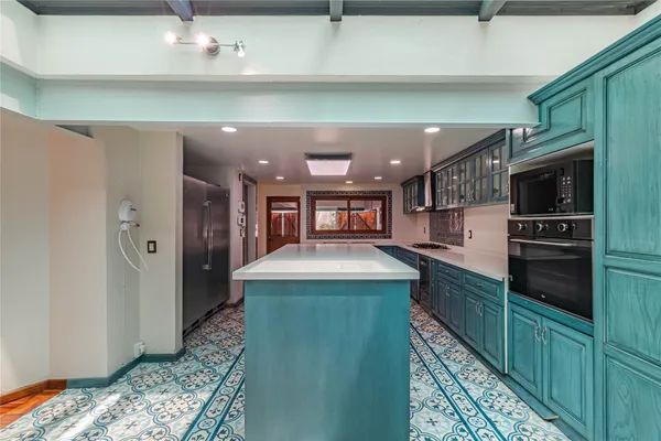 a kitchen with stainless steel appliances granite countertop a sink and a refrigerator