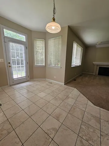 a view of empty room with a fireplace and window