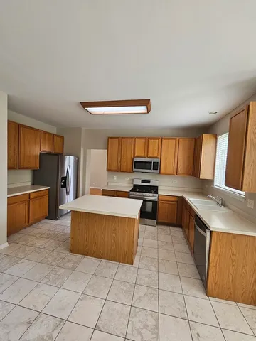 a large kitchen with a stove a sink and a refrigerator