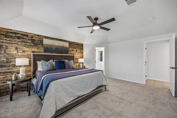 a bed room with a bed and a ceiling fan