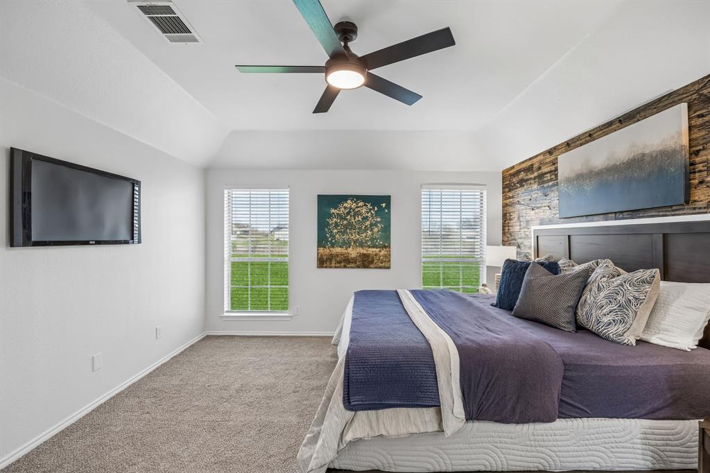 11090 Prairie Lakes Lane Forney, TX 75126 - Photo 18 of 40 a bedroom with a bed and a flat screen tv