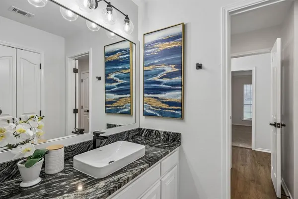 a bathroom with a granite countertop sink and a mirror