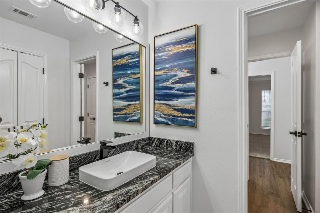 11090 Prairie Lakes Lane Forney, TX 75126 - Photo 23 of 40 a bathroom with a granite countertop sink and a mirror