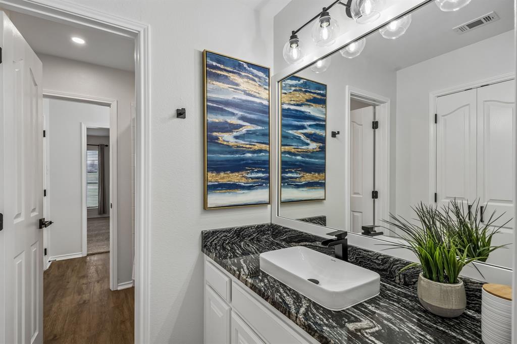11090 Prairie Lakes Lane Forney, TX 75126 - Photo 24 of 40 a bathroom with a granite countertop sink a mirror and a potted plant