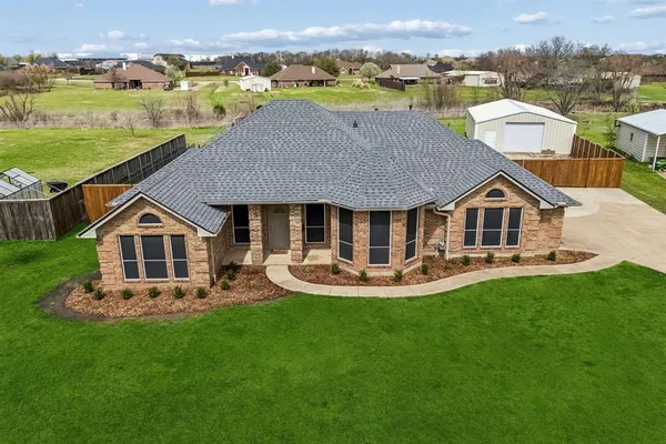 a aerial view of a house with swimming pool and a yard