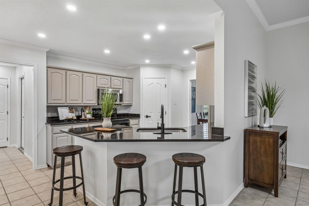 11090 Prairie Lakes Lane Forney, TX 75126 - Photo 7 of 40 a kitchen with white cabinets and stainless steel appliances