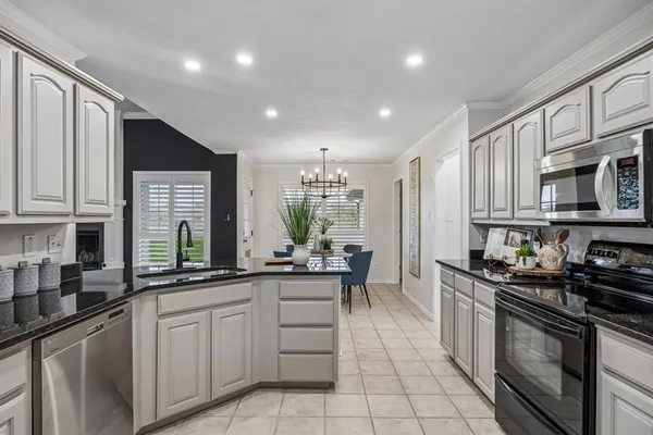 a kitchen with kitchen island granite countertop stainless steel appliances a sink stove top oven and cabinets