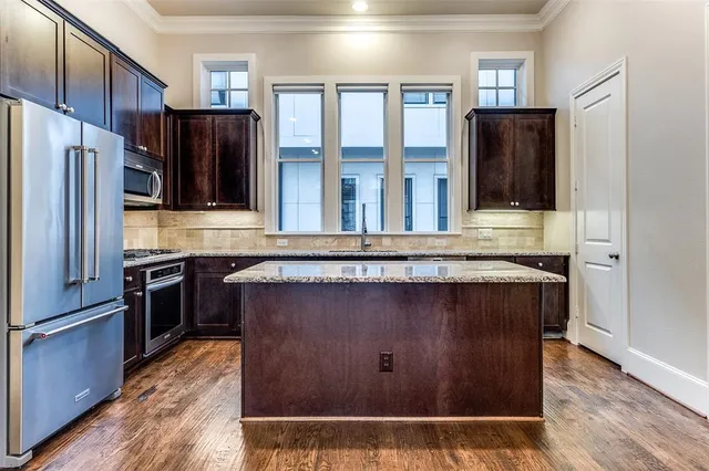 a kitchen with stainless steel appliances granite countertop a sink stove and refrigerator