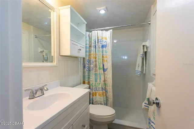 a bathroom with a sink toilet vanity and shower