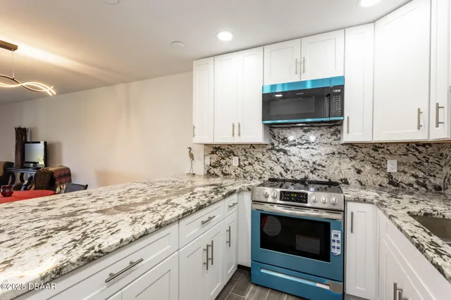 a kitchen with stainless steel appliances granite countertop a sink and a stove