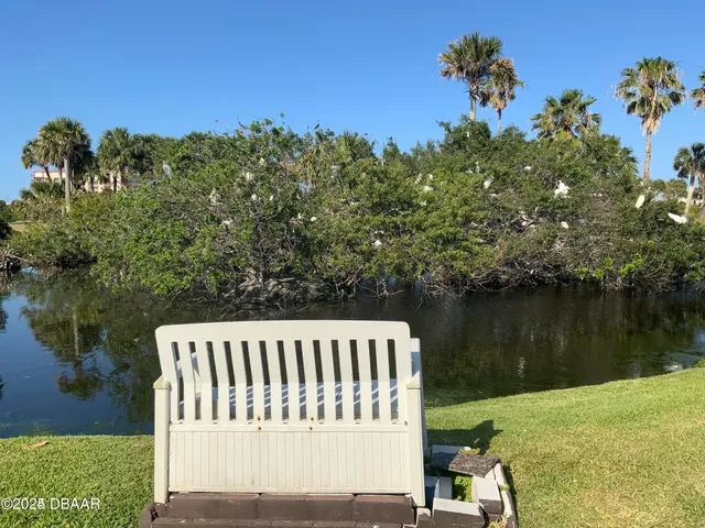 a view of a patio with table and chairs and potted plants with wooden floor and lake view