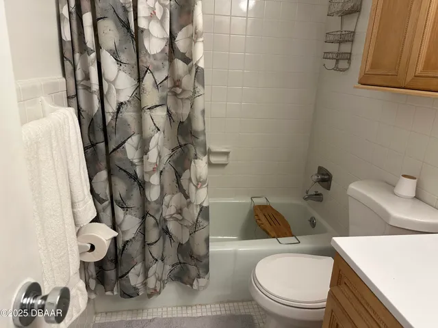 a white toilet sitting next to a shower curtain