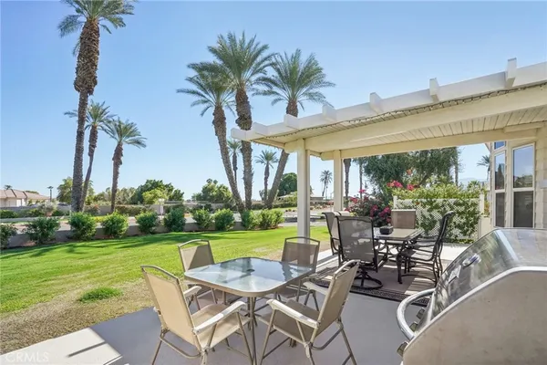 a view of a chairs and table in patio with a lake view