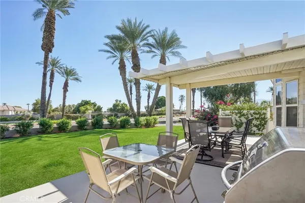 a view of a chairs and table in patio with a lake view