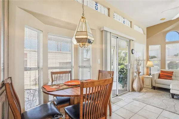 a dining room with furniture and a floor to ceiling window
