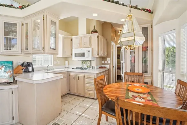 a open kitchen with a sink a stove a dining table and chairs