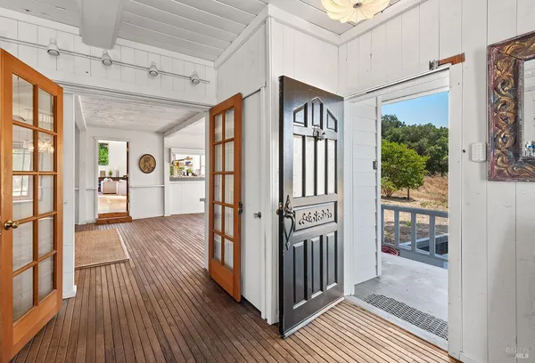 a view of a big room with wooden floor and windows