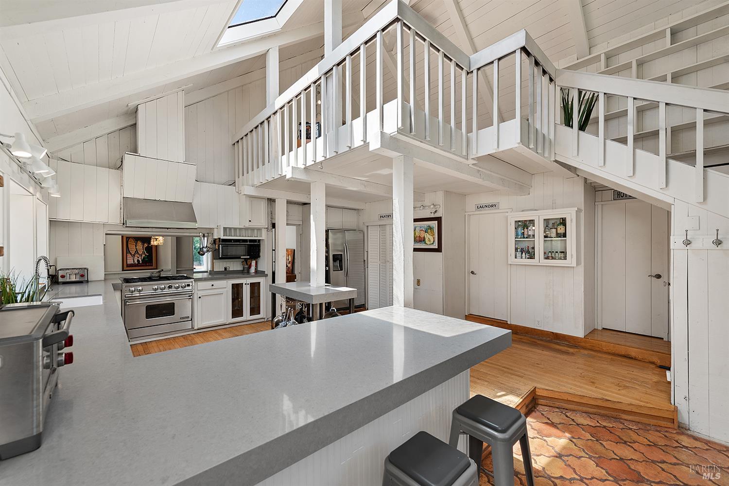 995 Dry Creek Road Healdsburg, CA 95448 - Photo 31 of 57 a kitchen with stainless steel appliances kitchen island granite countertop a refrigerator a stove a microwave oven with a dining table and chairs with wooden floor