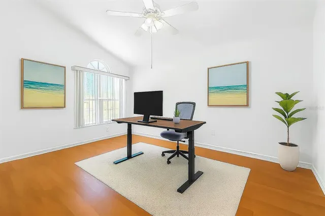 a view of an empty room with window and wooden floor