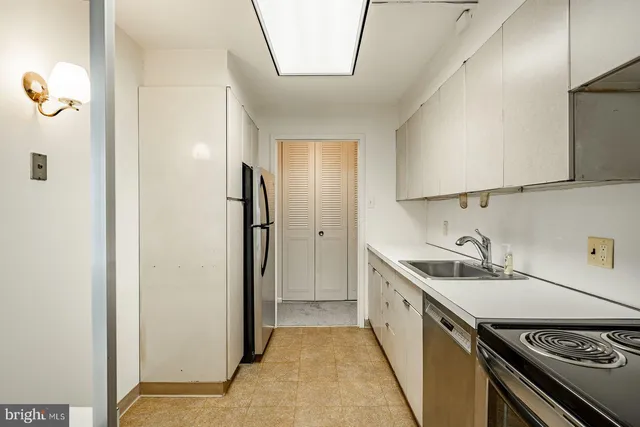 a kitchen with a sink a refrigerator and a stove top oven