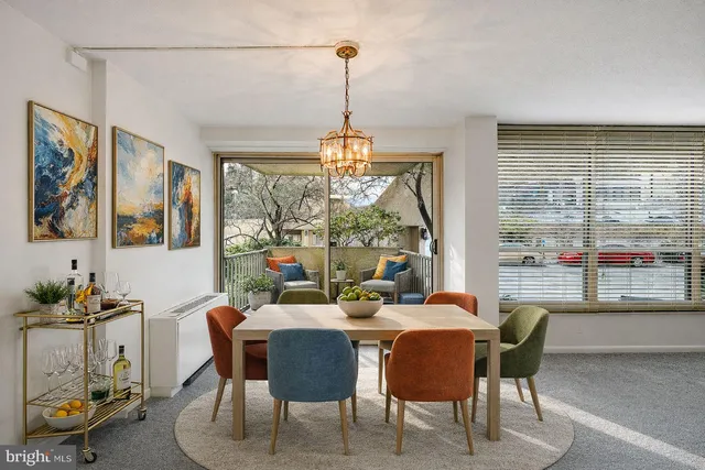 a dining room with furniture a chandelier and window