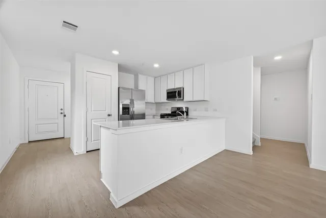 a kitchen with white cabinets and stainless steel appliances