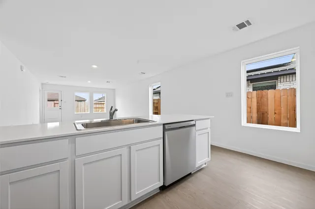 a kitchen with white cabinets and sink