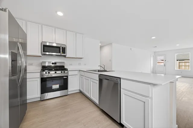 a kitchen with stainless steel appliances granite countertop a refrigerator stove and microwave