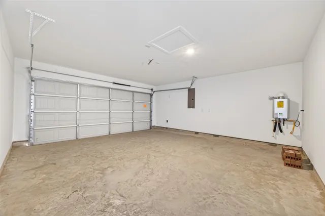 an empty room with chandelier fan and windows