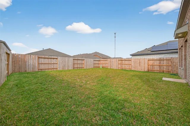 a view of a house with a backyard and a tree