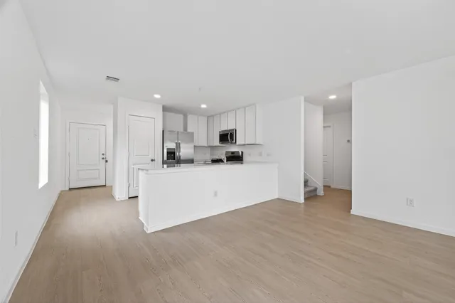 a view of a kitchen with refrigerator and white cabinets