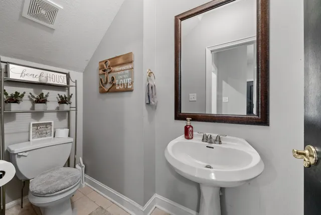 a bathroom with a sink toilet and mirror