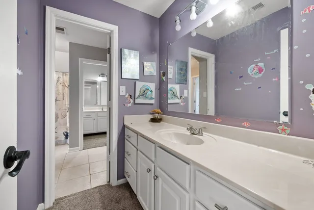 a spacious bathroom with a shower sink and mirror