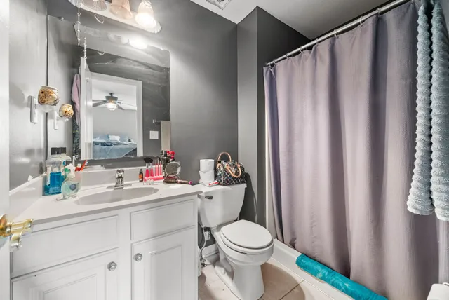 a bathroom with a sink a toilet and shower curtain