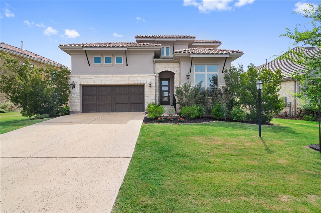 a view of a house with a yard and potted plants