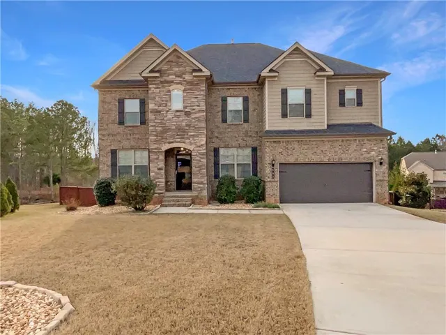a front view of a house with yard and parking