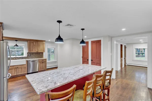a kitchen with granite countertop wooden floors and wooden cabinets