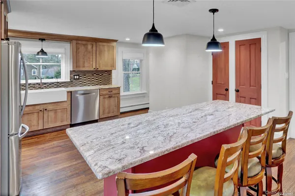 a kitchen with stainless steel appliances granite countertop a stove a sink and a refrigerator