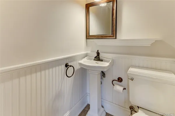 a bathroom with a sink a toilet and mirror