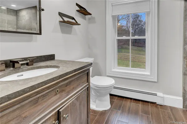 a bathroom with a sink a toilet and a window