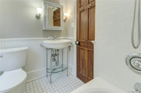 a bathroom with a toilet a sink and mirror
