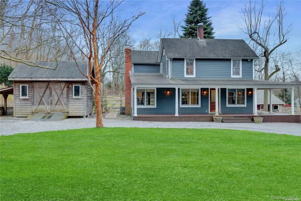a front view of a house with a garden and trees